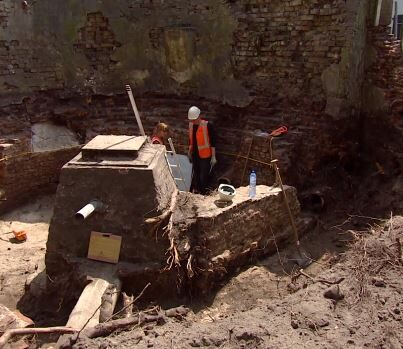 De opgegraven eerste stadsmuur en toren van de waterpoort