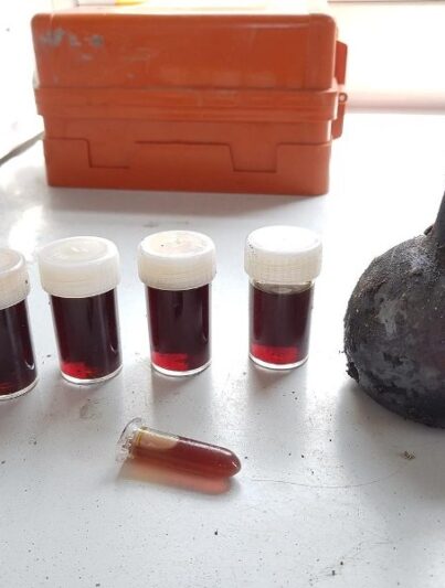 Het glazen drankflesje met daarnaast de inhoud