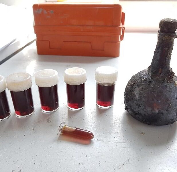 Het glazen drankflesje met daarnaast de inhoud