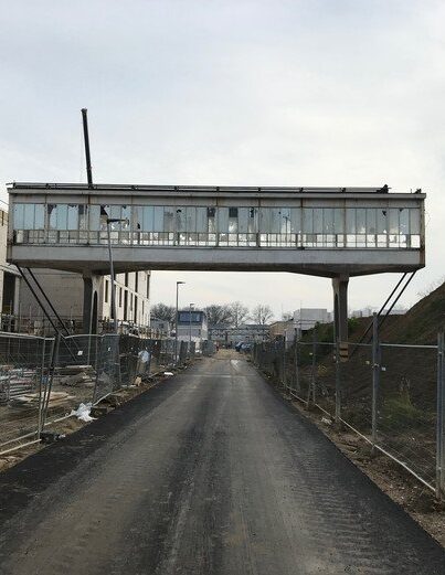 De woningen worden momenteel gebouwd, rechts van de loopbrug komt het Bruggegebouw