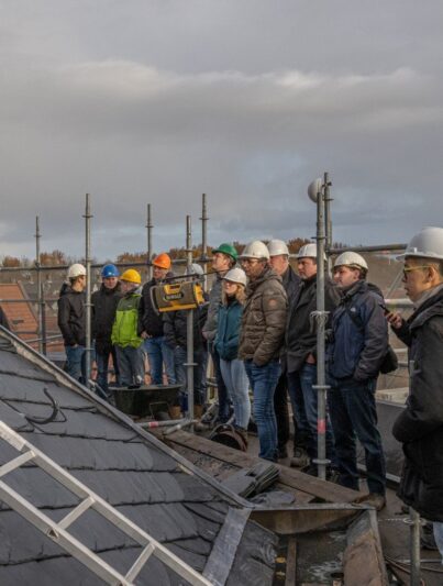 acko Engee (rechts vooraan met de witte helm) en de studenten van de NCE-opleiding Professional Restauratie krijgen uitleg van docent Klaas Boeder