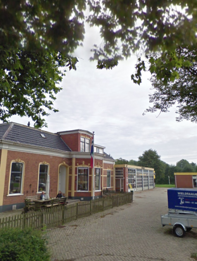 Het woonhuis met rechtsachter de werkplaats van de garage Warringa in Winsum