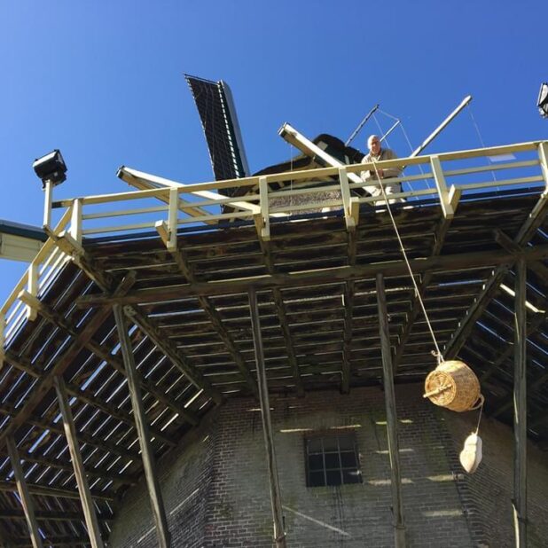 De molenaar van Molen Nooit Gedacht in Warnsveld laat een bestelling naar beneden zakken.